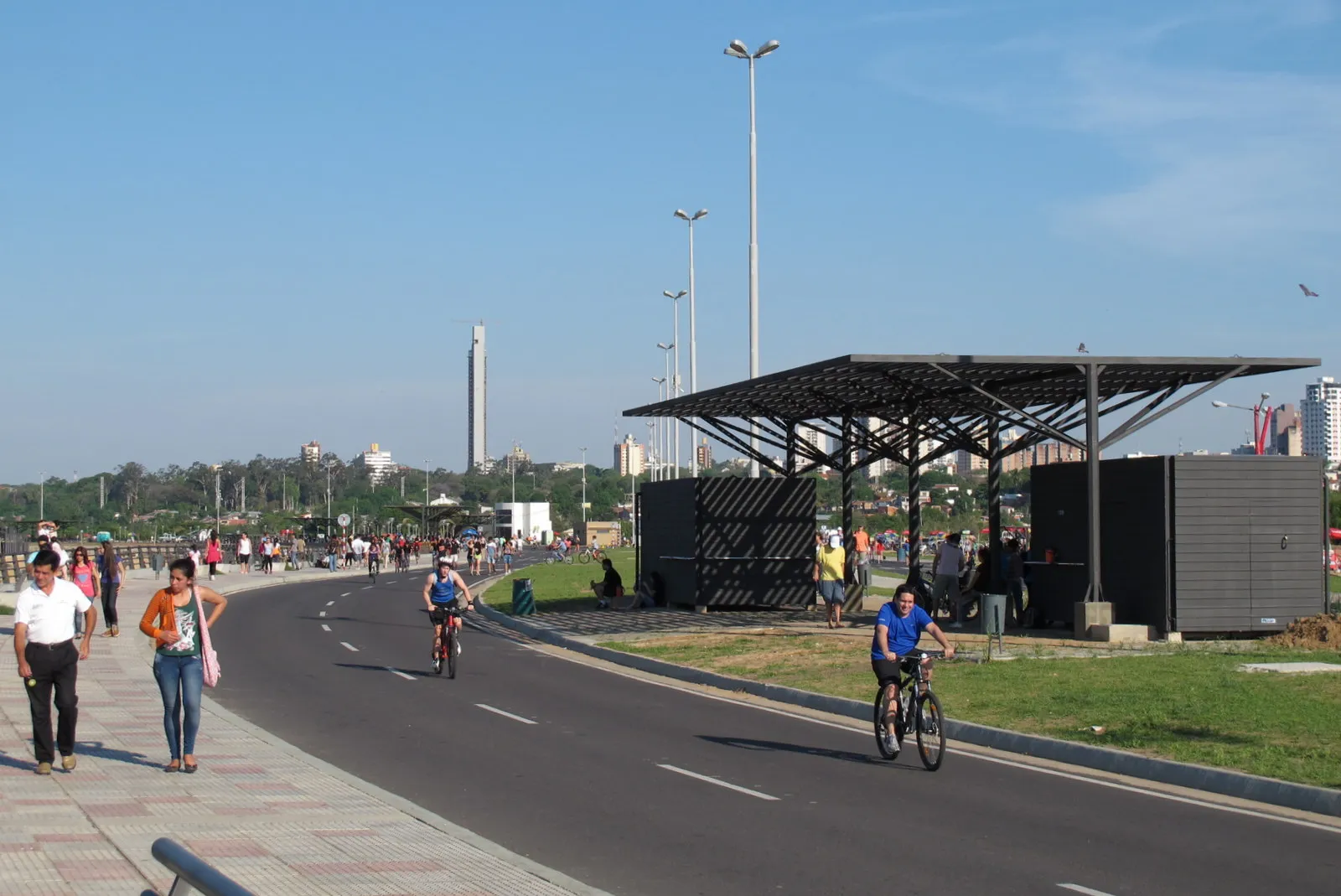 Wandelaars en fietsers op de costanera van Asunción, een beeld bij waarom Vlamingen naar Paraguay emigreren