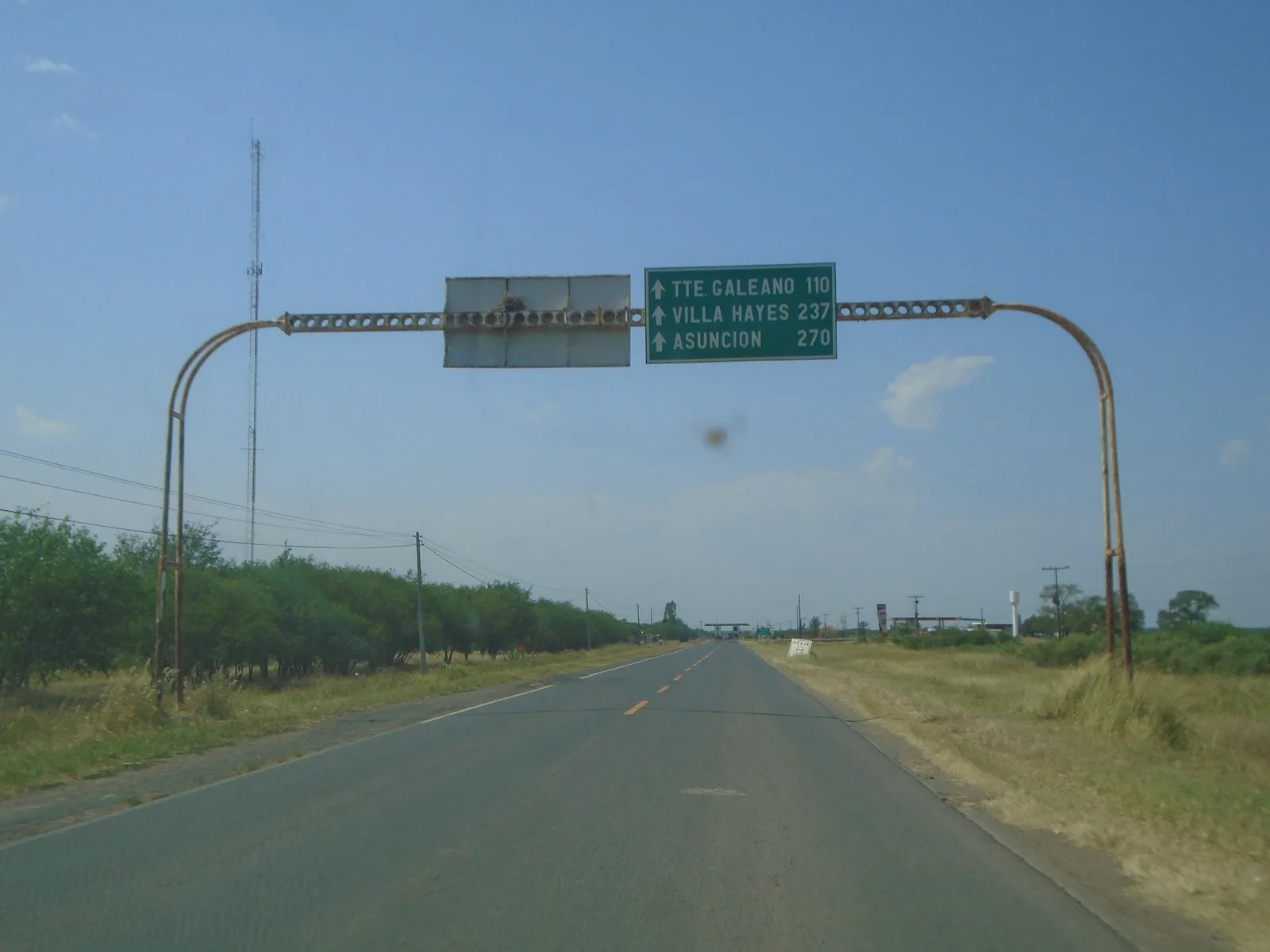 Wegwijzer op de Trans-Chaco-weg bij Pozo Colorado in de Paraguayaanse Chaco, waar afstand tot asfalt en haven de prijs per hectare mede bepaalt