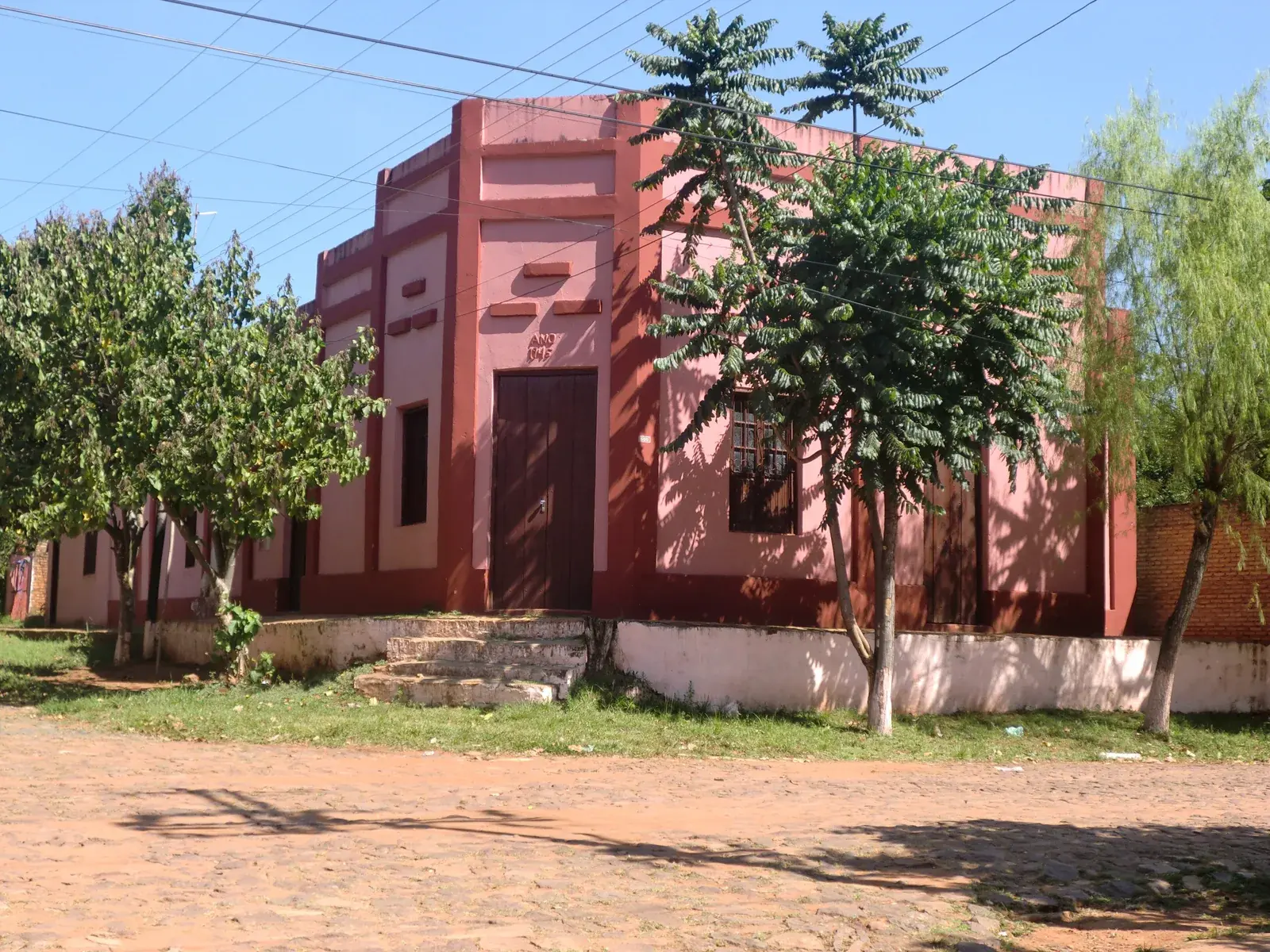 Een ouder woonhuis aan een onverharde straat in Quiindy, Paraguay; buiten de grote steden ontbreekt vaak een duidelijk huisnummer voor uw adresbewijs