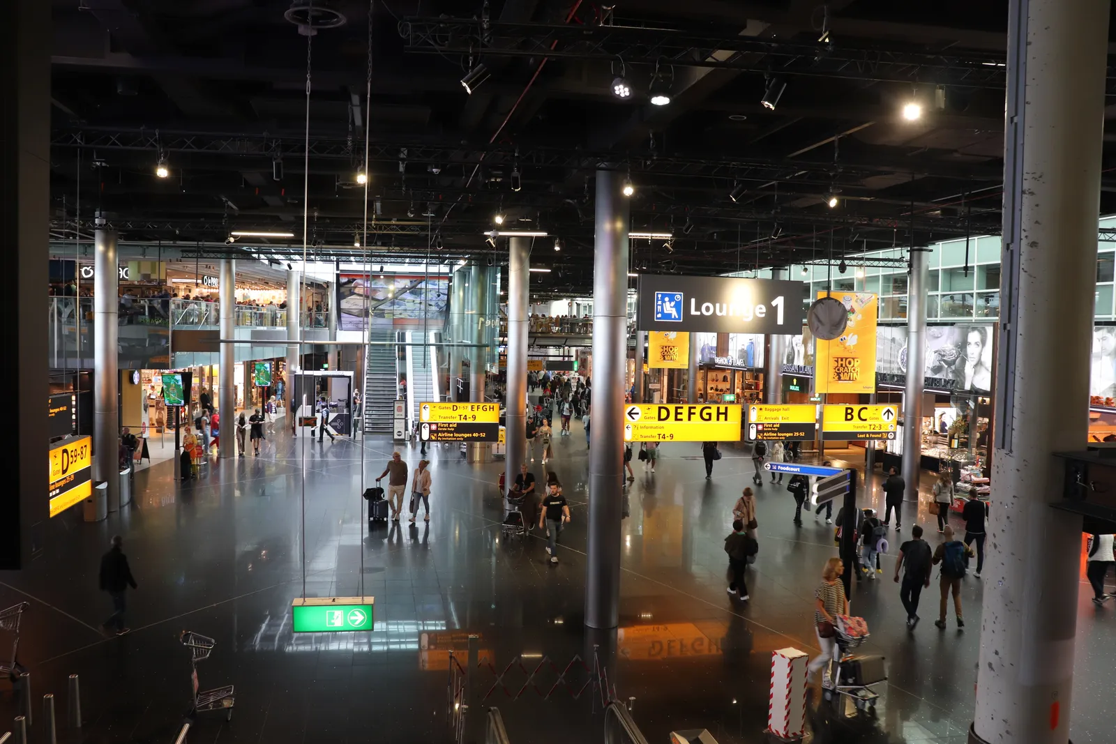 Vertrekgebied op Schiphol met borden naar de gates; vaak terugvliegen weegt zwaarder dan de 183 dagen telling
